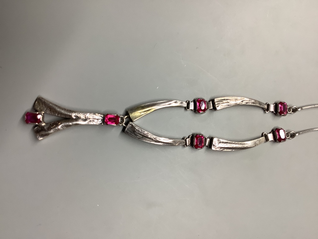 A modern stylish white metal and synthetic ruby set drop pendant necklace, 55 cm.